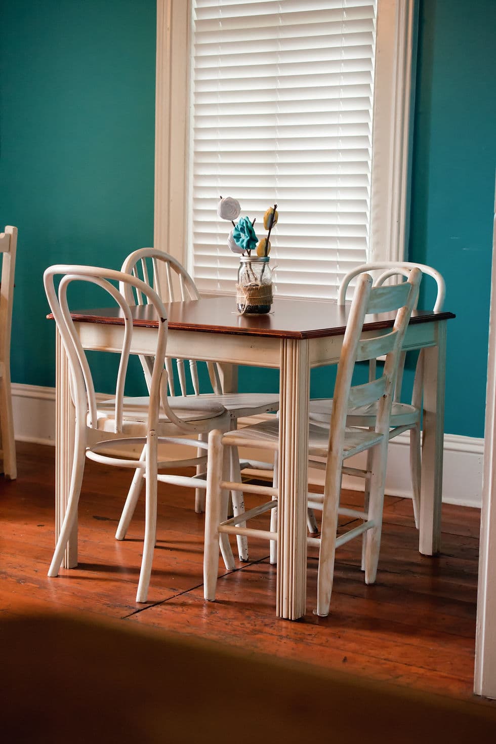 Vintage white dining table and chairs against a teal wall — When God Decorates