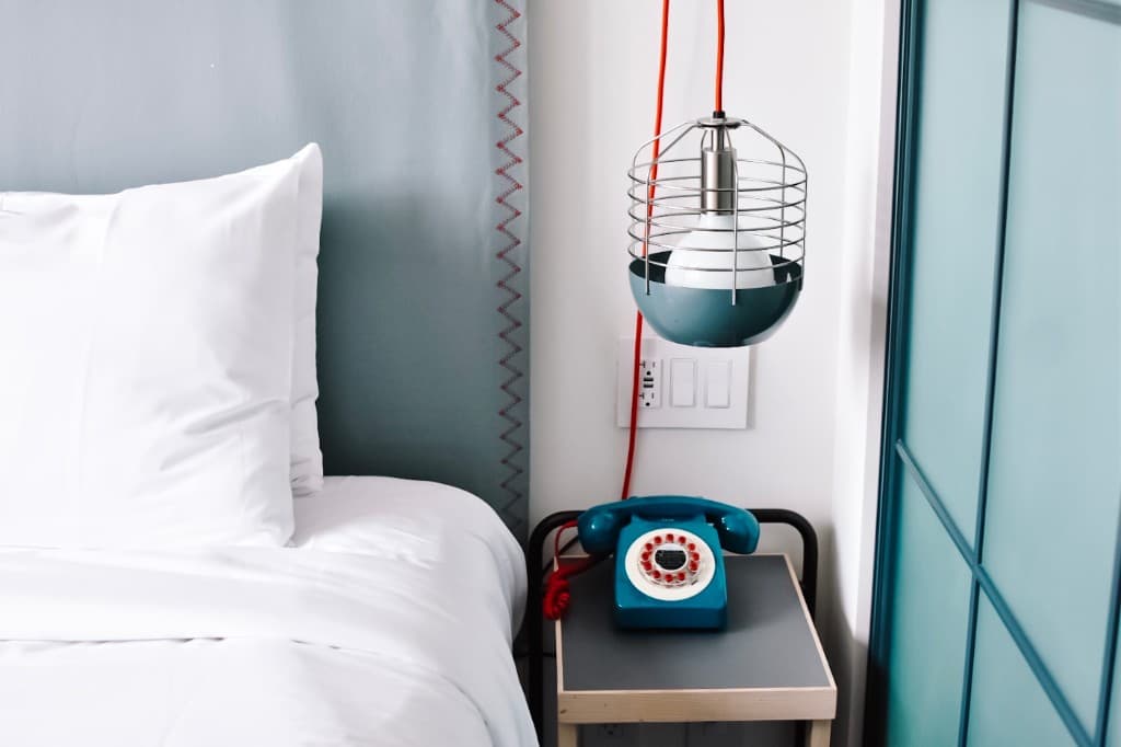 Teal rotary phone on a nightstand — Hope Furniture Ministry
